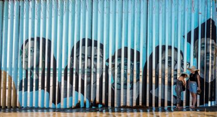 Los rostros de migrantes deportados son plasmados en el muro entre México y EU