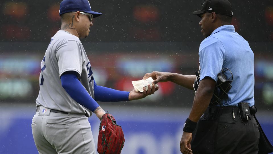 El umpire Edwin Moscoso verifica la bolsa de colofonia del mexicano (Foto: AP).