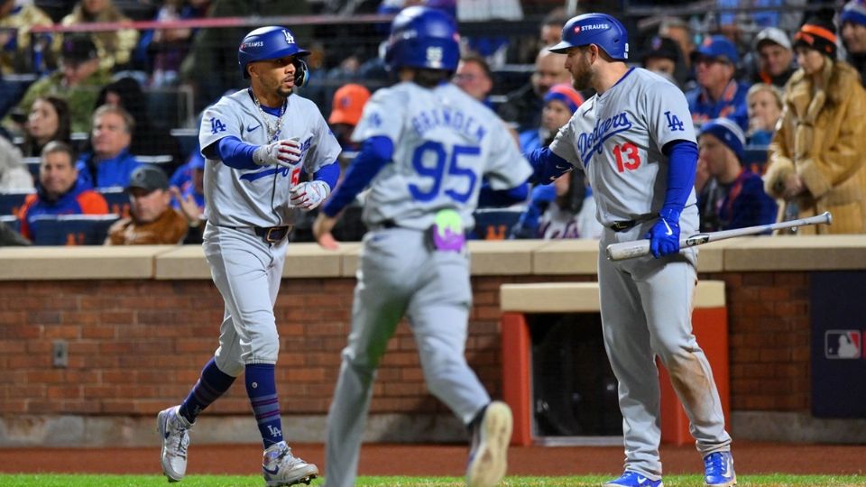 Mookie Betts (izq.) celebra con sus compañeros tras pegar de jonrón.