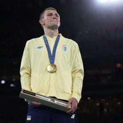 El boxeador Oleksandr Khyzhniak llora con el himno de Ucrania tras darle el oro a su país, azotado por la guerra